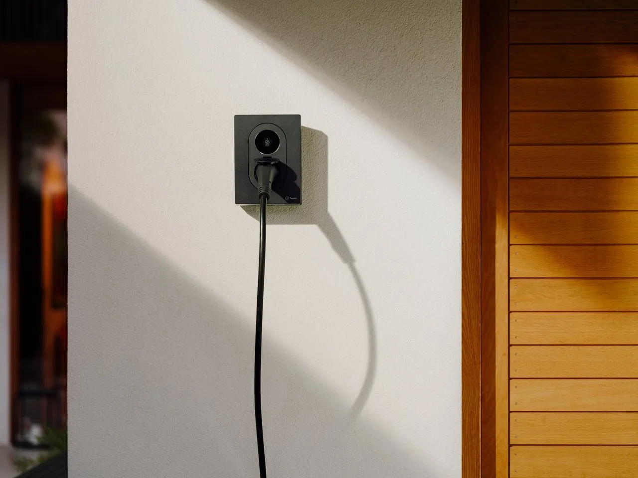 Zaptec Go 2 laadpaal laten installeren Zaptec Go 2 laadpaal in het zwart aan de gevel van een woning, met laadkabel in de Type 2 contactdoos
